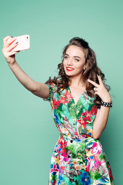 Fashionable woman showing peace and taking photo of herself