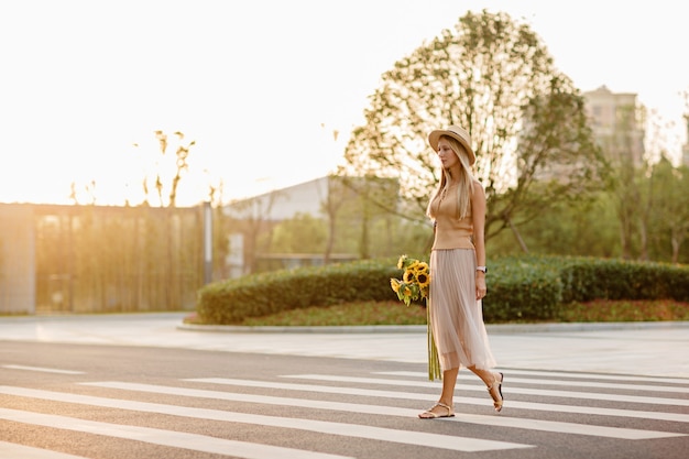 Fashionable woman in straw hat walking outdoor