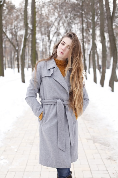 Foto donna alla moda che cammina in città in cappotto caldo