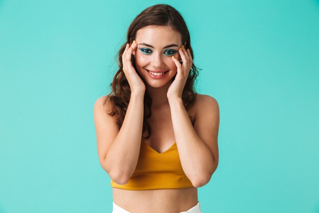 Fashionable woman with beautiful makeup smiling and holding cheeks