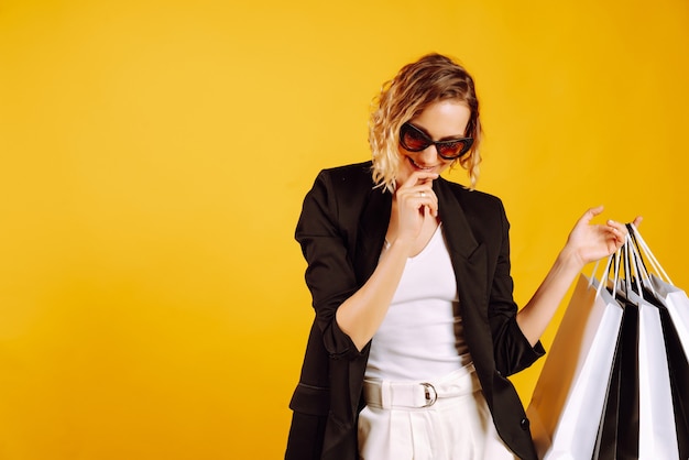 Fashionable woman with sunglasses holding shopping bags