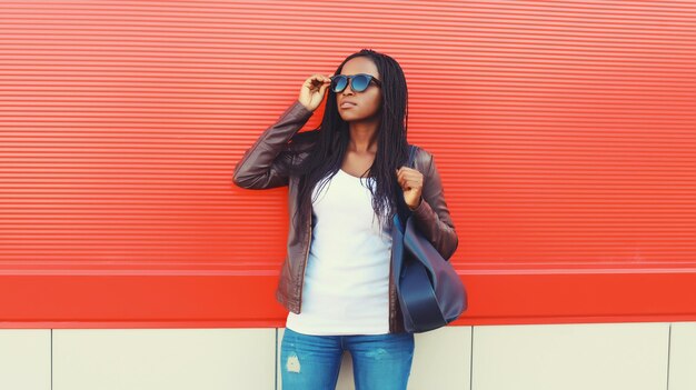 fashionable young african woman with handbag in casual stylish black girl posing in the city