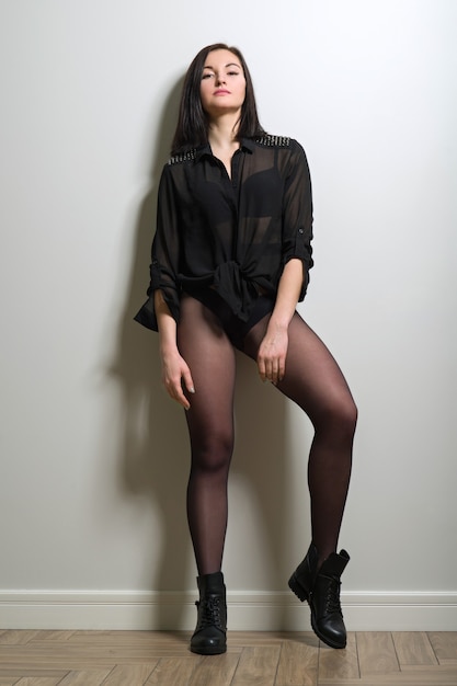 Модная молодая красивая женщина в черных нейлоновых колготках, стильных  кожаных сапогах и черной блузке | Премиум Фото