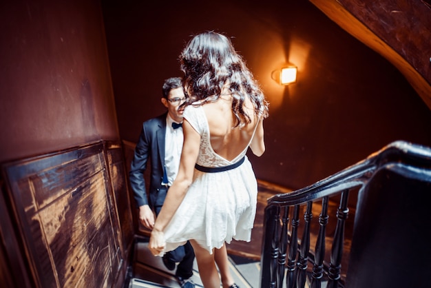 Fashionable young couple standing on stairs and hugging each other