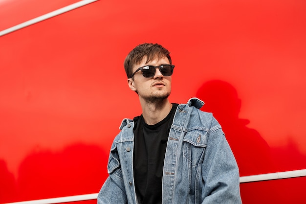 Fashionable young hipster man in a fashionable blue denim jacket