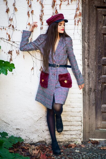 Fashionable young woman standing against old house