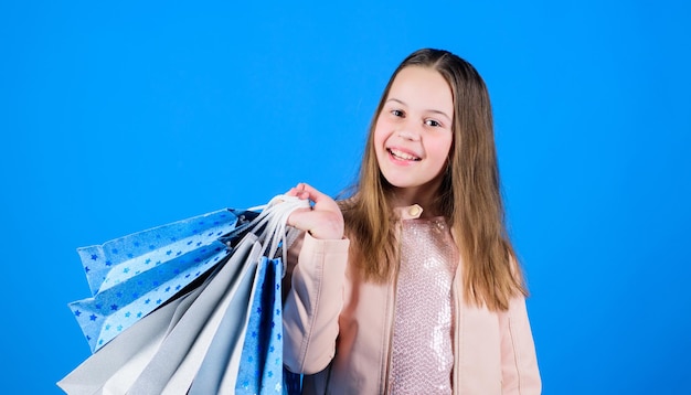 Fashionista addicted buyer Fashion boutique Birthday girl shopping Fashion trend Fashion shop Little girl with bunch packages Happy child in shop with bags Shopping day happiness Buy clothes