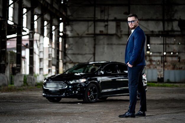 Fasion-fotoshoot van een man in elegante formele kleding. Jonge succesvolle rijke man op zwarte auto achtergrond. Detailopname.