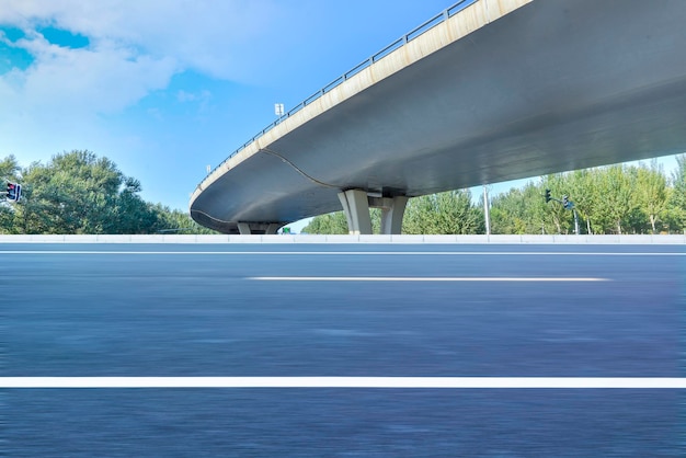 La veloce strada asfaltata sotto il viadotto del cielo blu