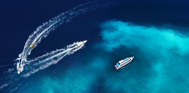 Fast boats on the sea in Bali Indonesia Aerial view on speed boats on blue water at sunny day Seascape from air Top view from drone Travel image