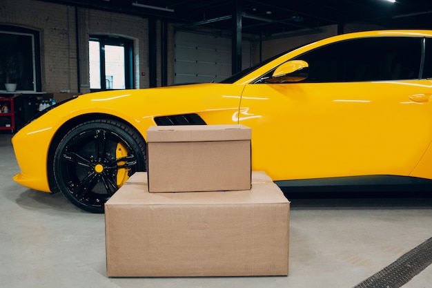 Fast delivery concept. Yellow sport car and boxes.