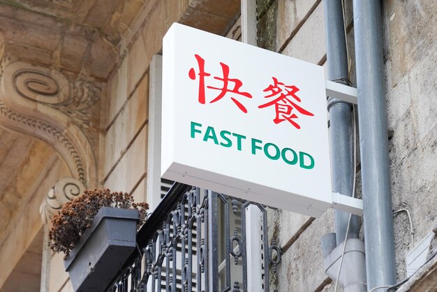 Testo asiatico del segno degli alimenti a rapida preparazione sul ristorante nell'edificio della facciata del negozio della via della città