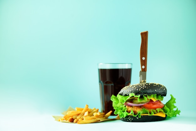 패스트 푸드 개념. 파란색 배경에 육즙이 수 제 햄버거. 식사를 빼십시오. 복사 공간 건강에 해로운 다이어트 프레임