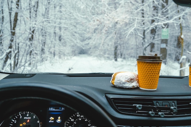 Fast food on a dashboard on the background of a winter forest