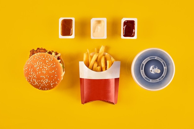 Фото Блюдо быстрого питания, вид сверху, мясной бургер, картофельные чипсы и дольки, композиция на вынос, картофель фри хамбу