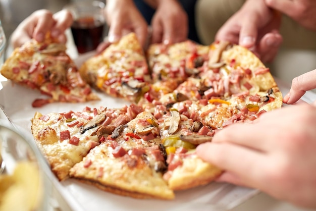 fast food, eating and people concept - close up of hands taking pizza slices