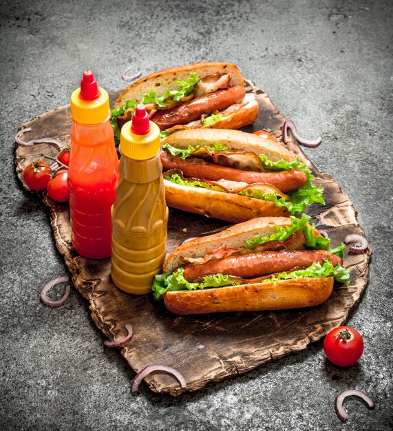 Fast food menu. Hot dogs beef barbecue with baconnd herbs on rustic table.
