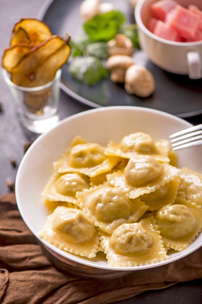 Fast food. Ravioli met spinazie en ricotta naast een laptop