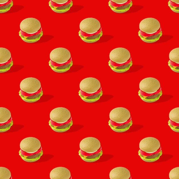 Photo fast food. seamless pattern of plastic childrens toy burger with salad, tomato, meat on red back