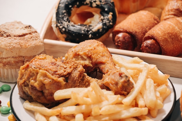 Fast food and unhealthy eating concept - close up of fast food snacks and cola drink on white table