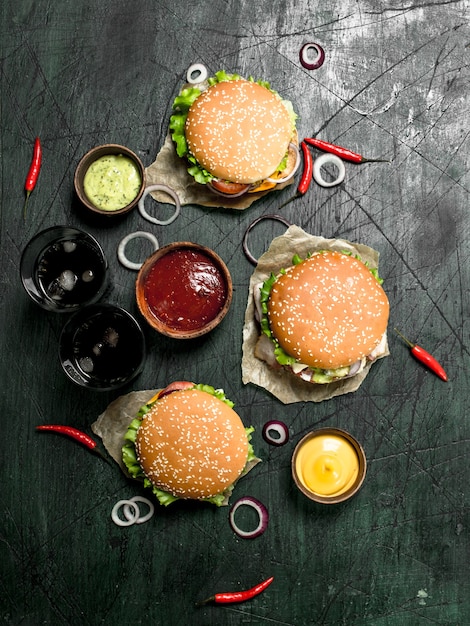 Fast food Verse hamburgers met cola op een rustieke achtergrond