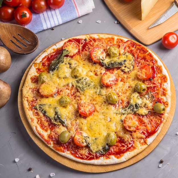 Fast homemade vegetarian pizza with mushrooms on a gray table