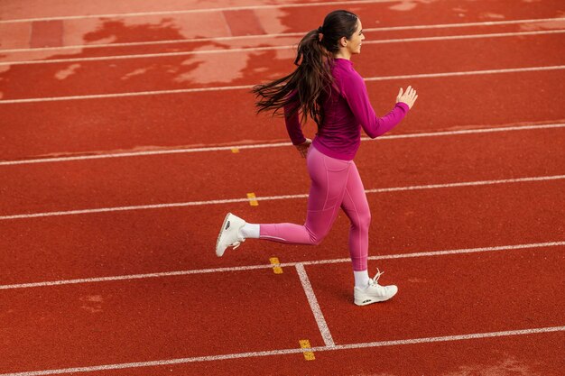 A fast sportswoman is running at stadium