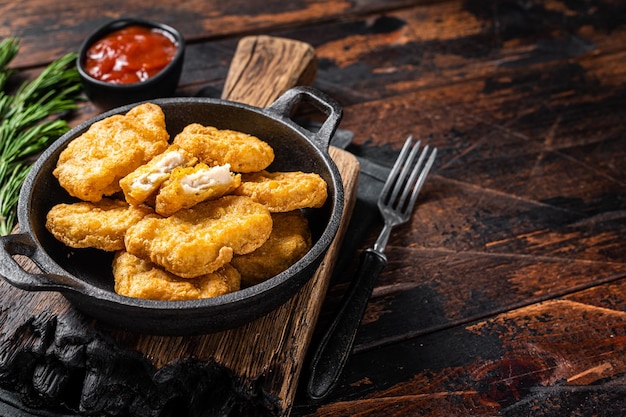 Fastfood pollo fritto pepite in padella sfondo in legno vista dall'alto copia spazio