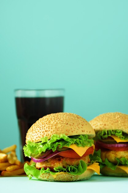 Foto fastfood frame heerlijke vleesburgers op blauwe achtergrond meeneemmaaltijd ongezond dieetconcept met kopieerruimte