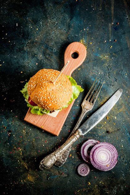 Fastfood Ongezond eten Heerlijke verse smakelijke hamburgers met rundvlees kotelet verse groenten en kaas op donkerblauwe concrete achtergrond