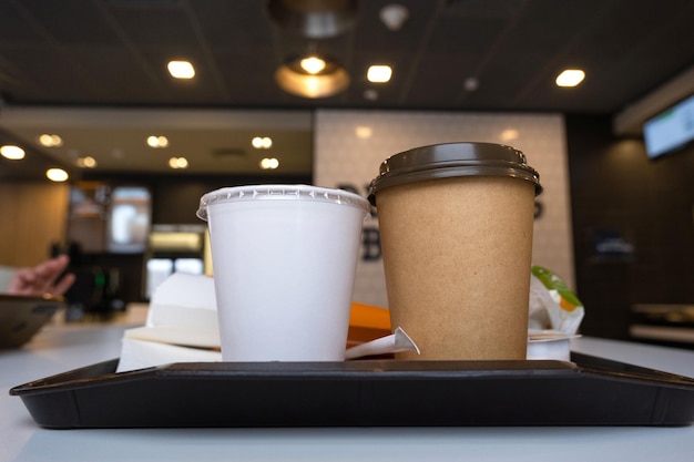 Fastfood op een dienblad in een restaurant Frieten een glas met een milkshake-koffie