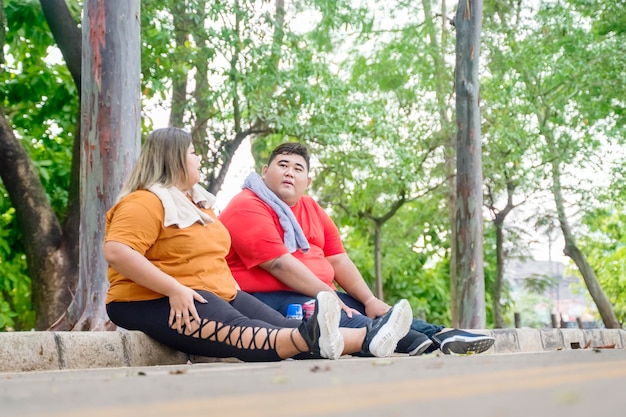 Fat Asian couple daydreaming while taking a break