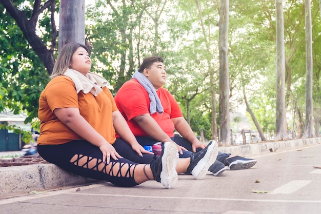 Fat Asian couple taking a break below the sunlight