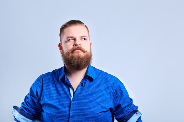 A fat, bearded man looks at the gray with a serious expression of emotion.