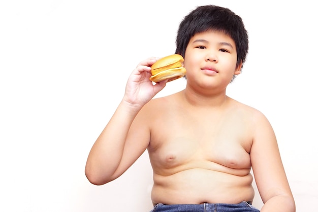 흰색 배경의 햄버거를 들고 있는 뚱뚱한 소년.