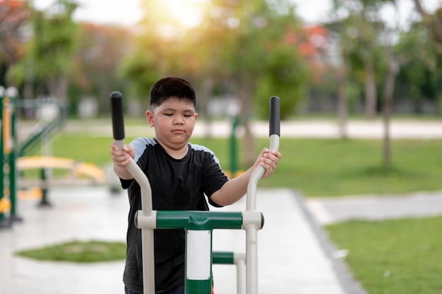 Fat boy traint op fitnessapparatuur in het park