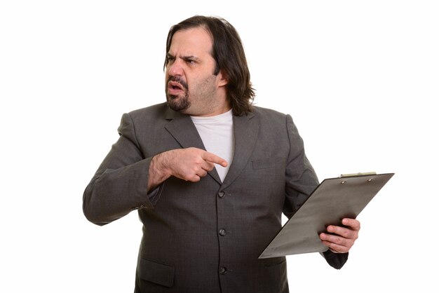 Fat Caucasian businessman looking angry pointing and holding clipboard