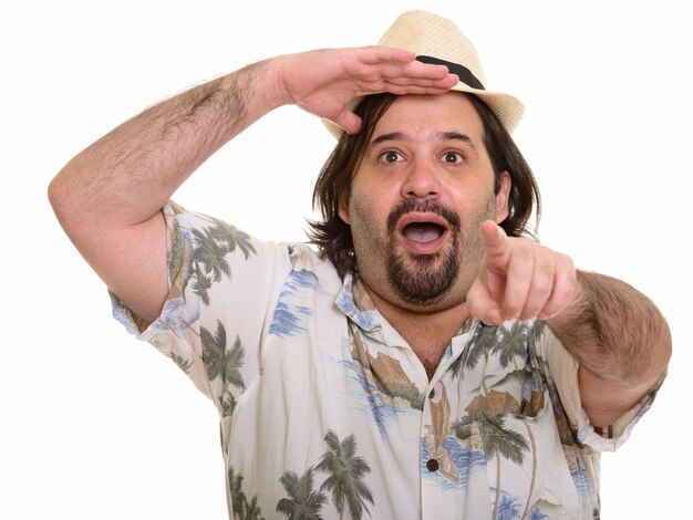 Fat Caucasian man looking amazed and pointing finger at distance isolated on white