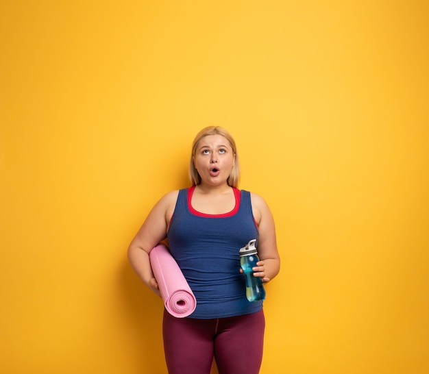 Fat girl does gym at home. surprised expression