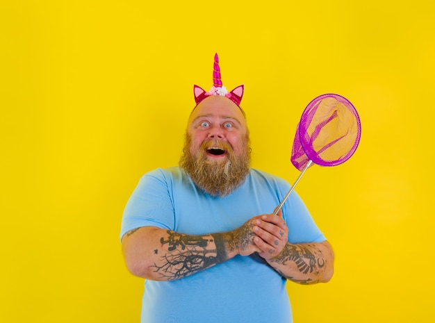 Fat happy man with headband play with sea net