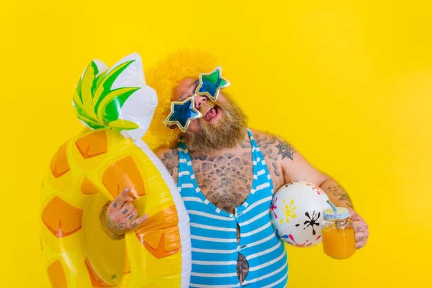 Photo fat happy man with wig in head is ready to swim with a donut lifesaver