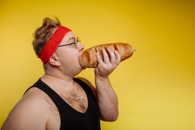 Fat man eating fast food hamburger