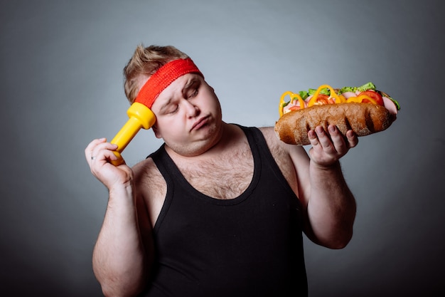 Fat man  and holding burger and dumbbell