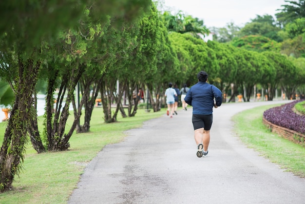 公共の公園でジョギングする太った男