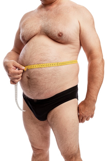 Foto un uomo grasso in pantaloncini misura il volume dell'addome. isolato. avvicinamento.