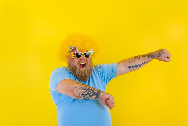 Fat man with wig in head and sunglasses dances