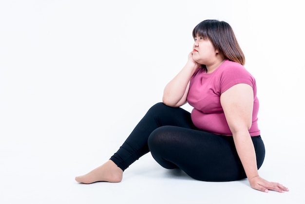 Foto seduta triste grassa della donna isolata