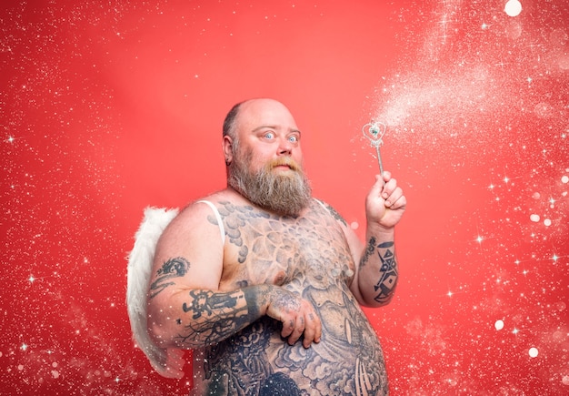 Fat thoughtful man with beard tattoos and wings acts like an magic fairy