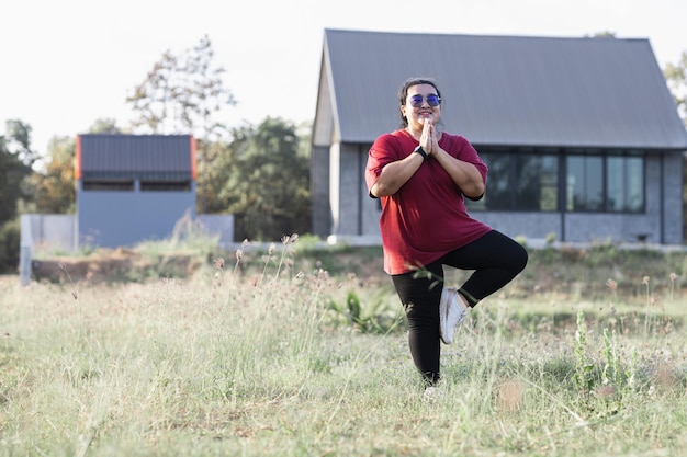 Foto donna grassa asia che fa yoga a casa