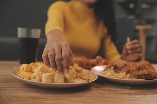 太った女性はピザを一口食べます太りすぎの女性はファーストフードを食べていますアジアの女の子はお腹が空いています